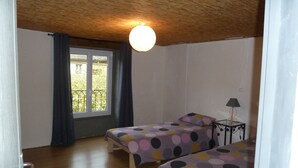 A room with two beds, a window with curtains, a ceiling light, and a small table with a lamp. - Village center, Village house for 4 people (Florac)