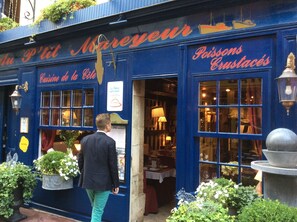Une devanture bleue avec une enseigne indiquant « Cuisine de la Coeur » et « Poissons et crustacés ».