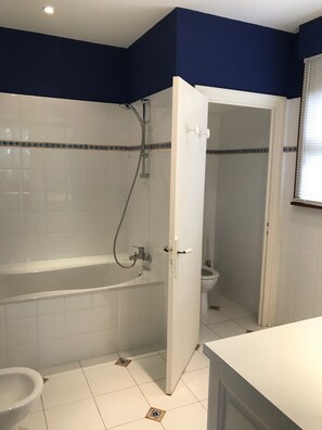 A bathroom with a bathtub, toilet, and shower.