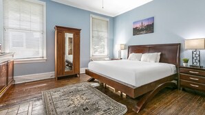 Un dormitorio con una cama grande, un armario de madera y una mesita de noche.