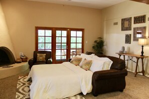 A bedroom with a large bed, a leather sofa, a fireplace, and a dining area with a table and chairs. - Dual Master Suite • Pool • Talking Stick• Sleeps 6 - Self Check In (Scottsdale)