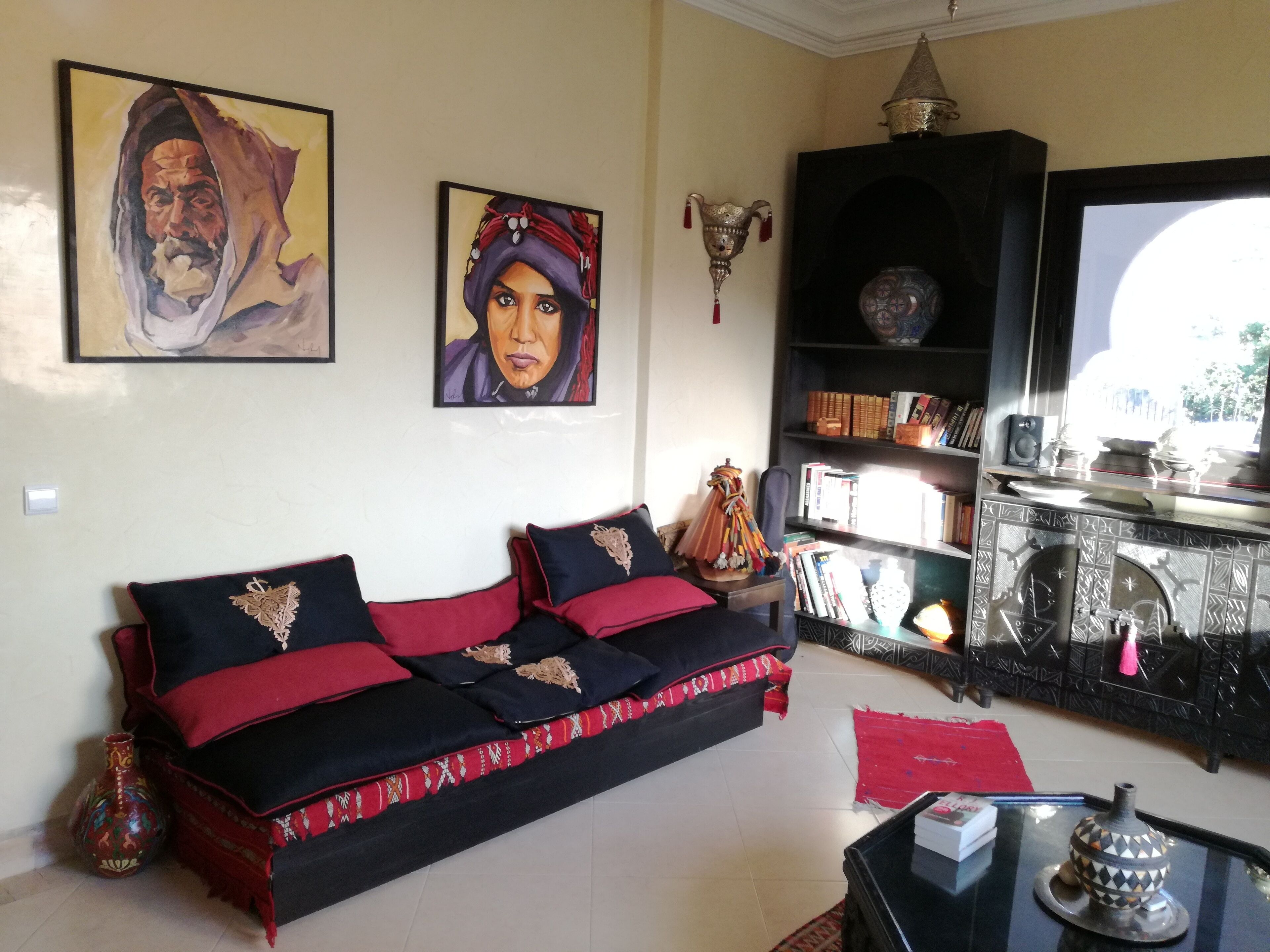 A living room with a sofa, a bookshelf, and a decorative lamp.