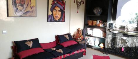 A living room with a sofa, a bookshelf, and a decorative lamp.