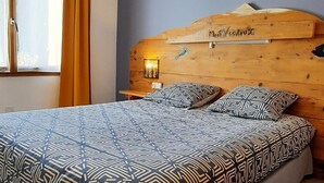 Un dormitorio con una cama grande, cabecera de madera y un cuadro en la pared.
