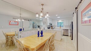 Una cocina moderna con armarios blancos, electrodomésticos de acero inoxidable y una isla grande con asientos.