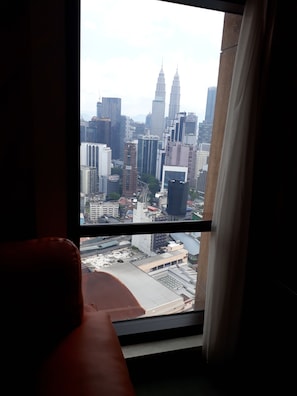 A view from a window with a cityscape, including tall buildings and a bridge. - Cool Service Suites at Times Square (Kuala Lumpur)
