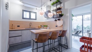 A modern kitchen with a central island, bar stools, pendant lighting, and a view of the outdoors. - Villa Vikor with large private swimming pool and jacuzzi..... (Dubrovnik)