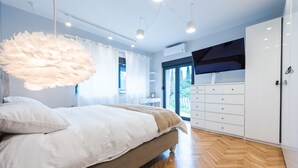A modern bedroom with a large bed, a hanging light fixture, and a wardrobe. - Villa Vikor with large private swimming pool and jacuzzi..... (Dubrovnik)