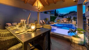 An outdoor dining area with a pool, wicker furniture, and a view of the neighborhood. - Villa Vikor with large private swimming pool and jacuzzi..... (Dubrovnik)
