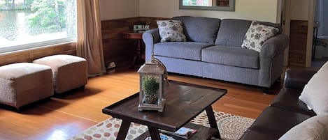 Una sala de estar acogedora con un sofá gris, una mesa de centro y una alfombra estampada.