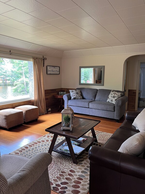 A cozy living room with a grey sofa, a coffee table, and a patterned rug.