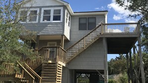 Ein zweistöckiges Haus mit überdachter Veranda und Garage.