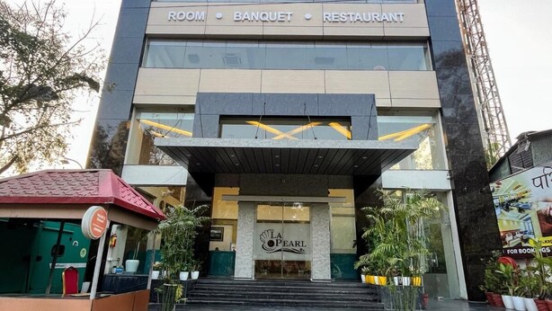 Ein Gebäude mit einem Schild, das „LA PEARL ROOM BANQUET RESTAURANT“ zeigt, und einem Logo einer gelben Muschel.