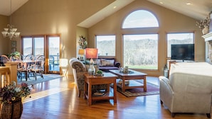 A spacious living room with a high ceiling, large windows, a fireplace, and a television. - 3 Bedroom, 3 1/2 bath house in The Galena Territory. (Galena)