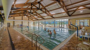 An indoor swimming pool with wooden beams, clear glass walls, and a tiled floor. - 3 Bedroom, 3 1/2 bath house in The Galena Territory. (Galena)
