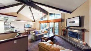 A spacious living room with a fireplace, a dining area, and a kitchen visible through an open door. - Sleep 6 With Stunning Views Of Lake Tahoe  (Incline Village)