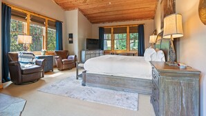 A spacious bedroom with a large bed, wooden ceiling, and a view of the outdoors through large windows. - RMR: Granite Ridge Homestead 3132 in Teton Village (Teton Village)