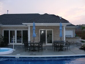 A house with a patio, outdoor seating, and a swimming pool. - Reunion Paradise! Spacious Luxury Home and Pool House (Virginia Beach)