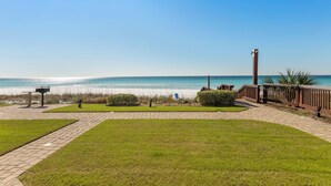 Un sendero pavimentado que lleva a una playa, con una vista despejada del océano.