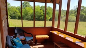 A covered porch with wicker chairs, a bench, and a table. - SUNDANCER CABIN CADDO RIVER!!!!!   GREAT GETAWAY !!!!!!!! River Access!! (Glenwood)