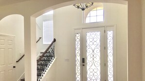 A staircase with a wooden handrail and white walls. - Spacious Modern Retreat for Family Fun Near Tampa! (Riverview)