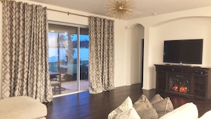 A modern living room with a sofa, a television, and a fireplace. - Spacious Modern Retreat for Family Fun Near Tampa! (Riverview)