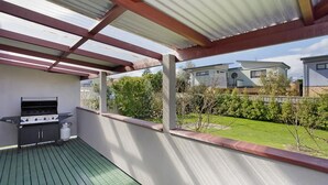 A covered outdoor area with a barbecue grill and a wooden deck. - Bella Vista - Apollo Bay (Apollo Bay)