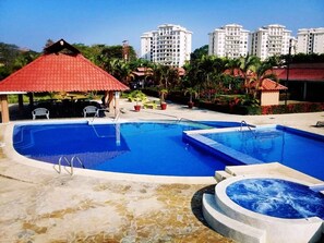 A swimming pool with a hot tub, lounge chairs, and a gazebo. - VILLA JACO B47 - FOR YOUR GREAT VACATIONS (Jacó)
