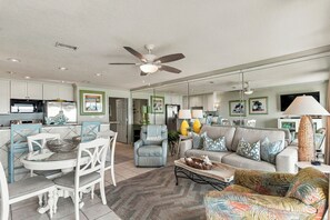 A spacious living area with a dining table, chairs, a sofa, and a coffee table.