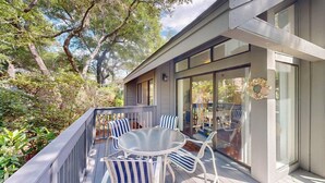 A modern house with a balcony, a round table, and striped chairs. - Perfect Location for a Family Vacation! (Hilton Head)