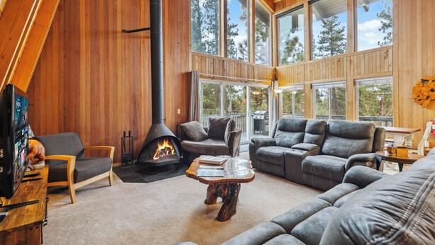 Una sala de estar acogedora con chimenea, ventanas amplias y asientos c ómodos.