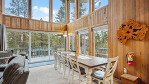 Un interior de madera con zona de comedor, ventanas amplias y un extintor.