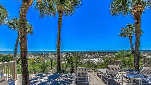 A deck with lounge chairs and a view of the beach. - Top floor vacation rental - expansive ocean views and steps from the beach! (Hilton Head)