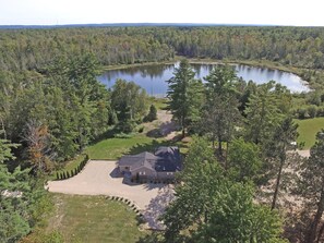 Ein Haus, umgeben von Wald und See.