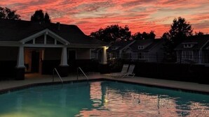 Una piscina con el cielo de la puesta de sol al fondo.