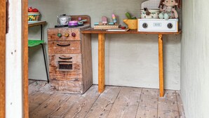A rustic kitchen with wooden cabinets, a vintage stove, and a small table with kitchen utensils. - Mandala Bruny Island, waterfront, near Restaurant (Alonnah)