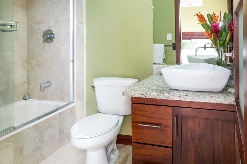 Une salle de bain comprenant une baignoire, des toilettes, un meuble-lavabo et un miroir.