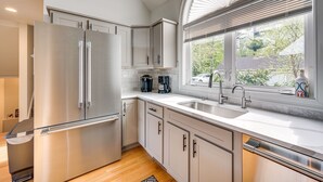 A modern kitchen with stainless steel appliances, white cabinetry, a large window with blinds, and a view of the outdoors. - In the Estates, close to Owl's Nest, new kitchen, amazing views, minutes off I93 (Thornton)