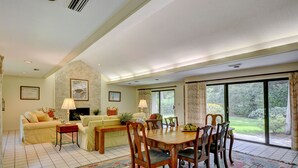 A spacious living room with a dining area, large windows, and a fireplace. - Excellent Cottage Location on Sea Island (Sea Island)