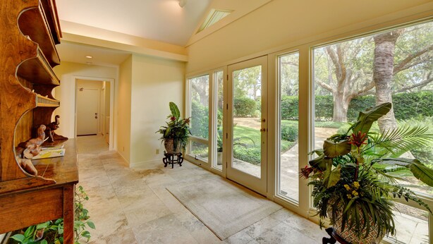 A spacious hallway with large windows, a wooden piano, and potted plants. - Excellent Cottage Location on Sea Island (Sea Island)