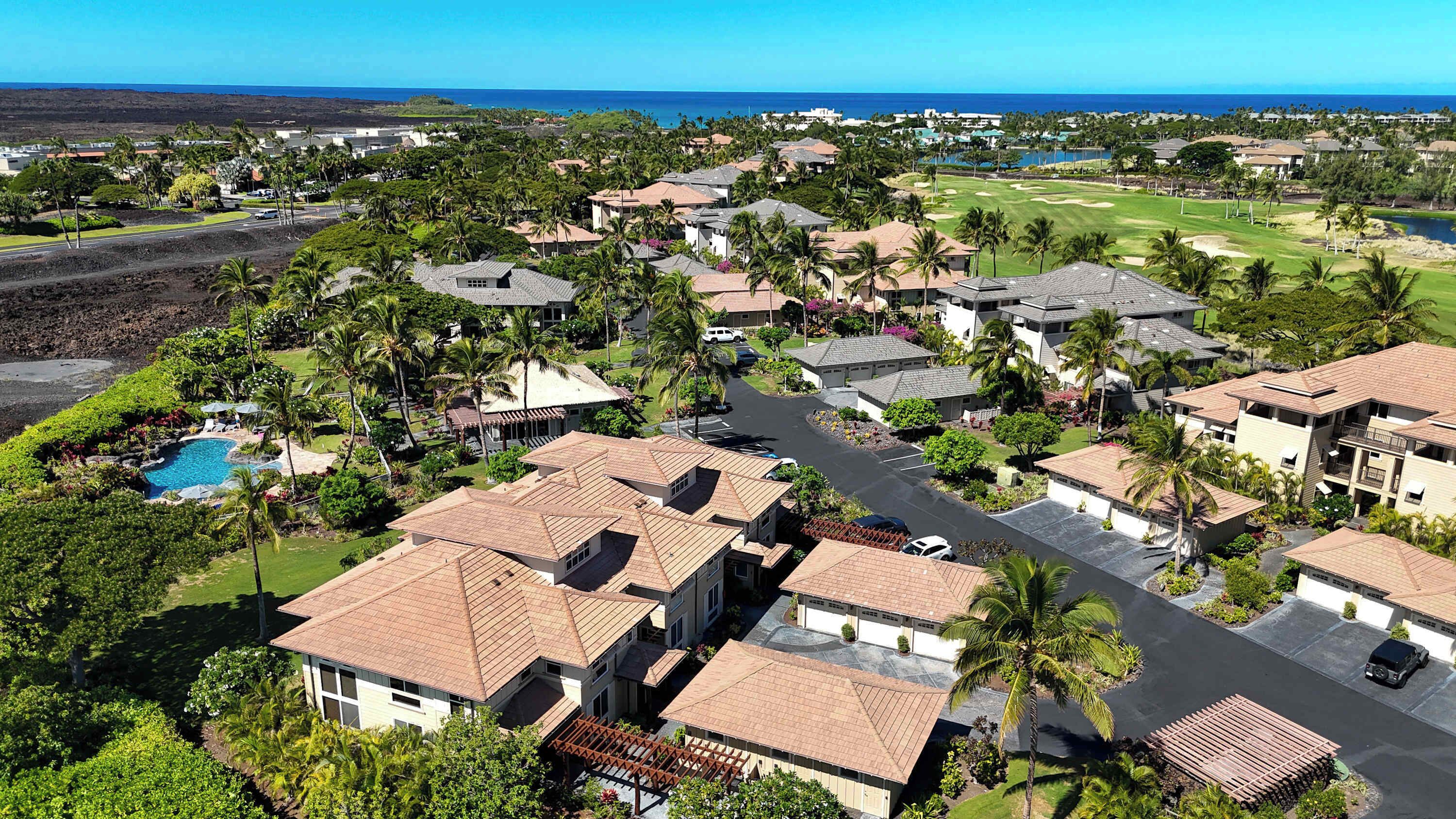 A residential area with houses, a golf course, and a pool.