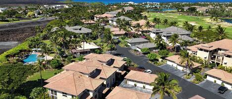 A residential area with houses, a golf course, and a pool.