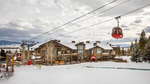 A large lodge with multiple floors and a ski lift in the background. - RMR: Cody House C Condo in Teton Village (Teton Village)