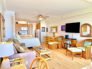 A spacious living area with a sofa, armchairs, a coffee table, and a television. - Junior Suite Oceanfront #906 (Kaanapali)