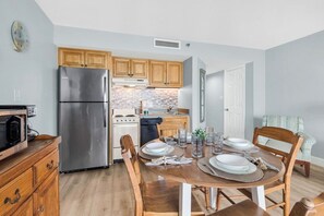 Une cuisine avec des meubles en bois, un réfrigérateur en acier inoxydable, une cuisinière et un lave-vaisselle.