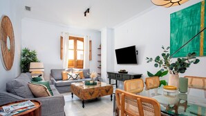 A modern living room with a sofa, coffee table, and dining area.