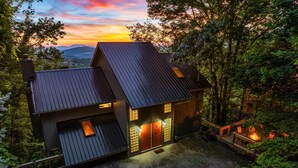 A modern house with a sloped roof, large windows, and a porch area. - Incredible Views! Massage Chairs, Hot-tub, WiFi (Gatlinburg)