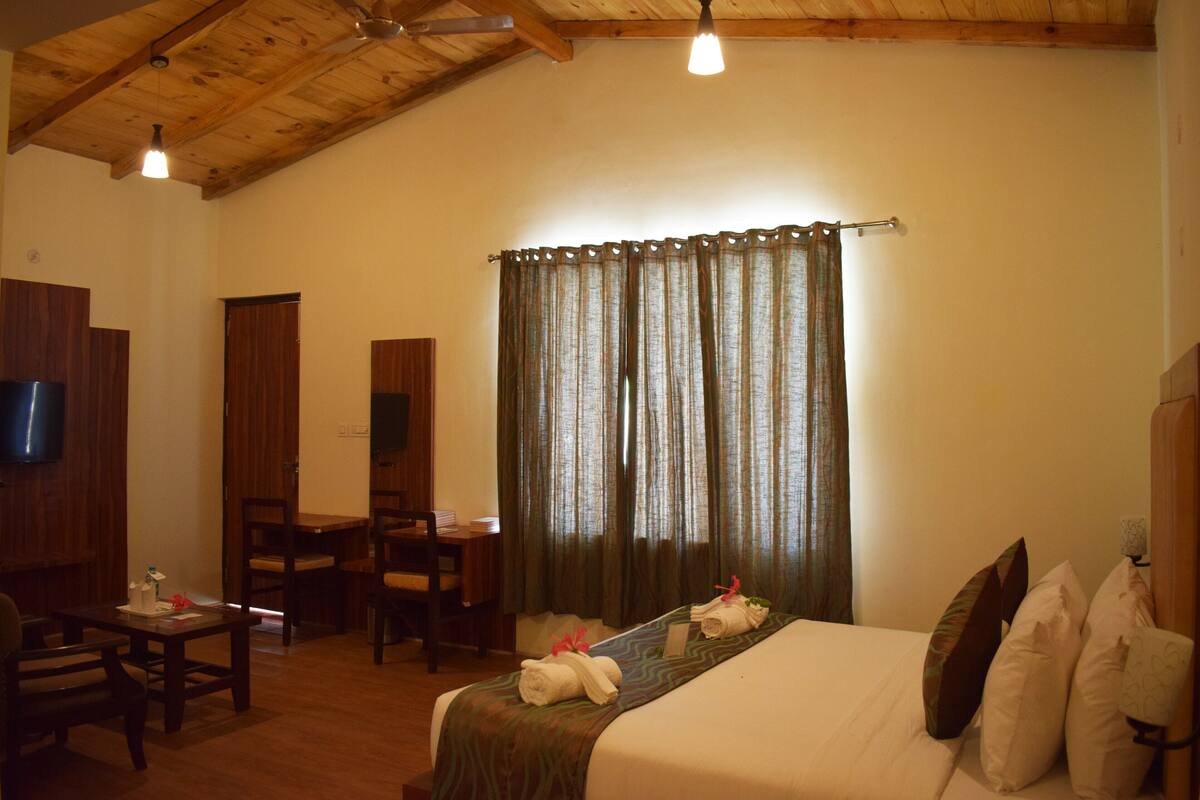 Una habitación de hotel con una cama, un escritorio y un televisor.