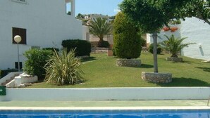 A swimming pool with a white building in the background. - Residencial Itxaso 8 LEK (Peñiscola)