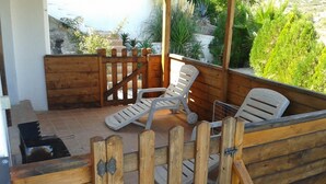 A wooden deck with two lounge chairs and a grill. - Residencial Itxaso 8 LEK (Peñiscola)